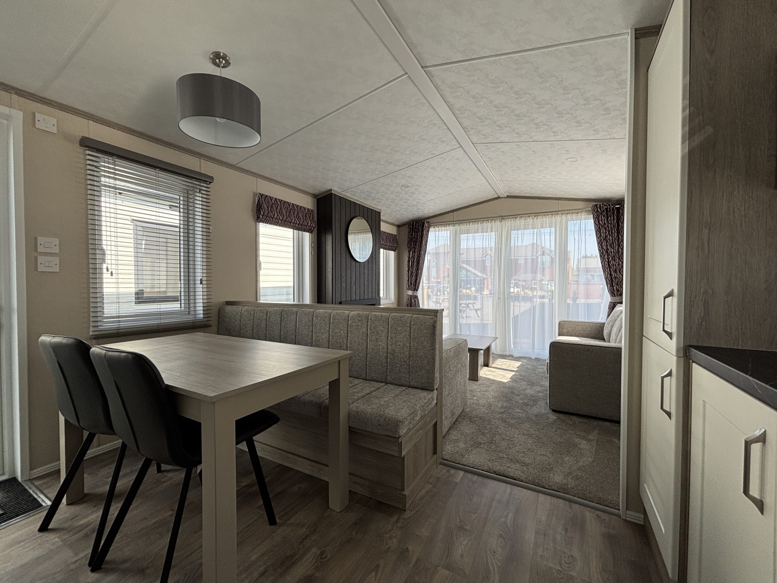 An image of the dining area through to the lounde, looking towards the floor to ceiling patio doors - Pemberton Marlow 2026