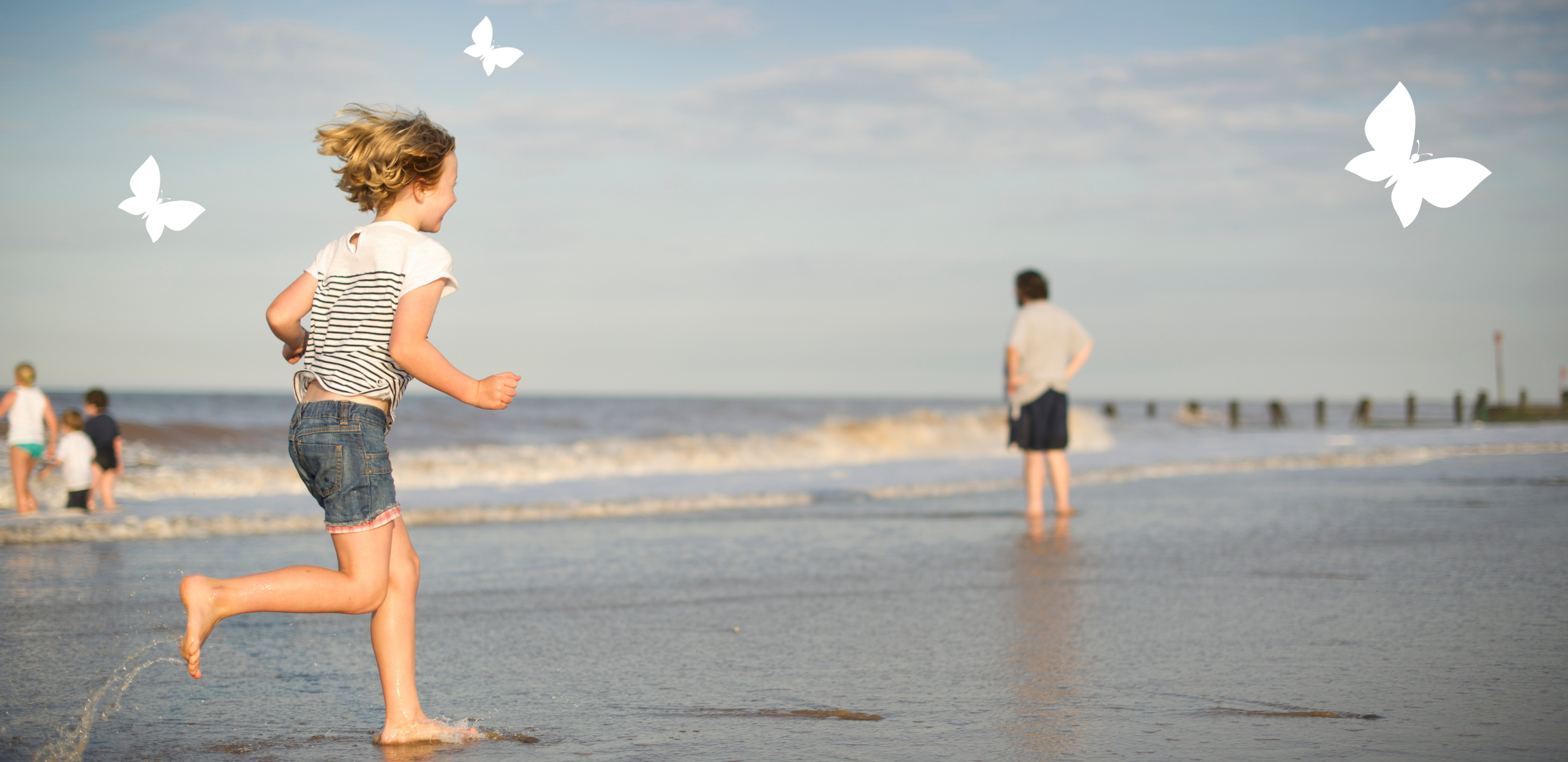 Child running on beach next to the shore