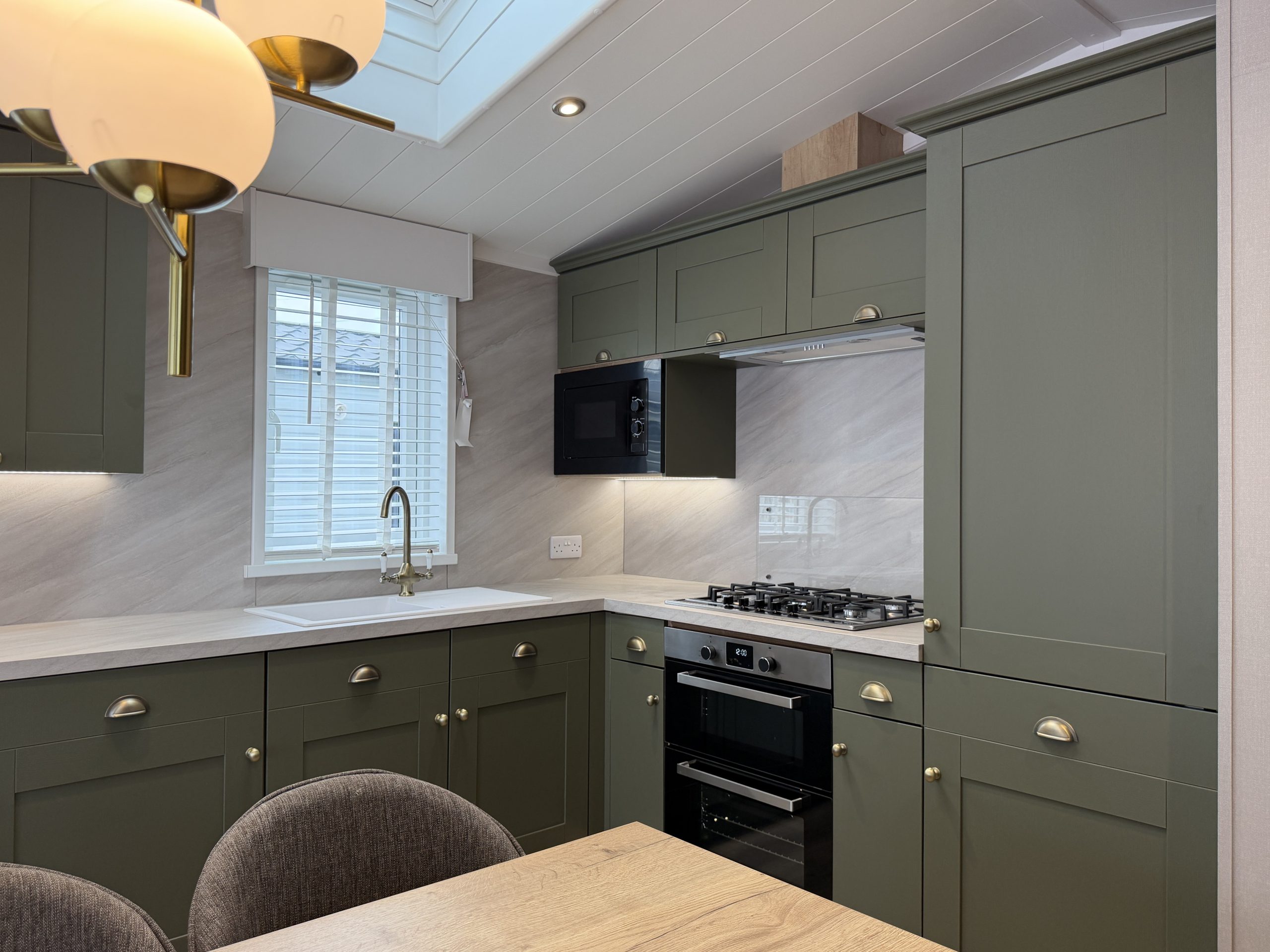 Photograph of the kitchen with integrated appliances in the Swift Vendee Lodge 2026 at Broadwater Holiday Park, Partington's